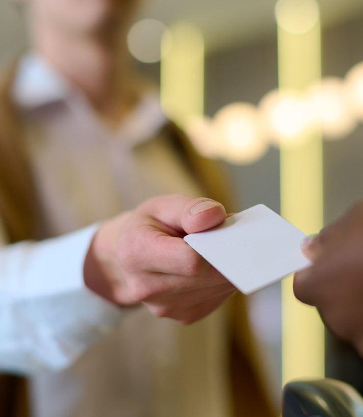 Hand handing over a white key card